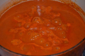 Simmering curry base sauce. Note the pale colored froth that forms around the smooth sauce in the middle, and needs to be skimmed off.